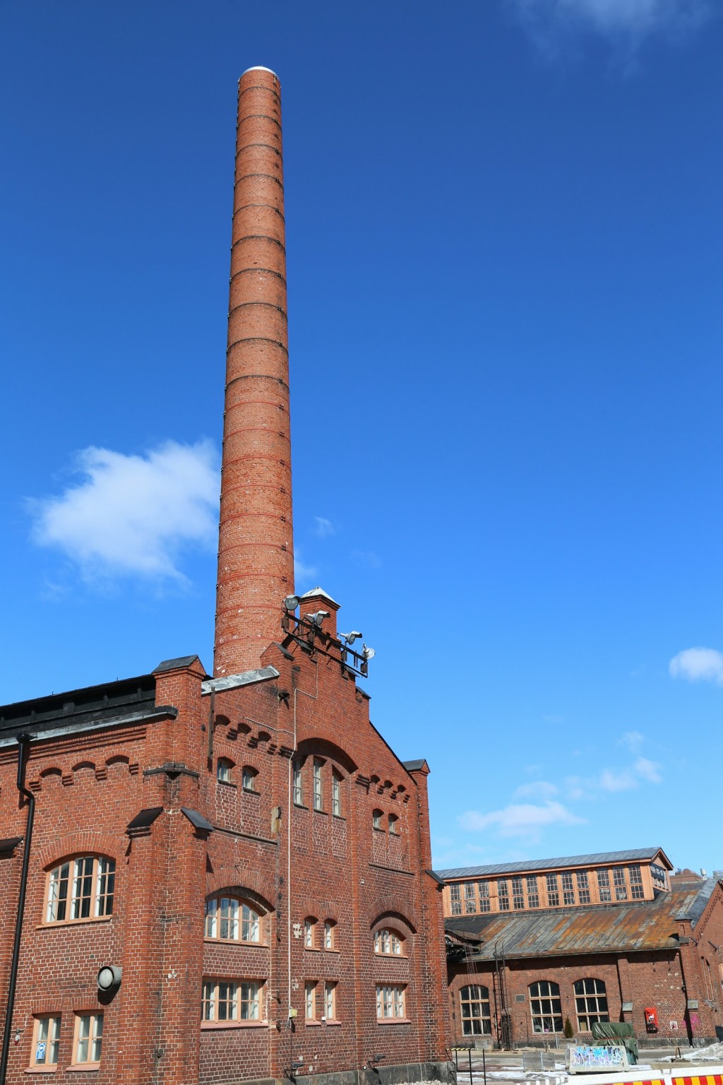 Large brick industrial building with a tall chimney